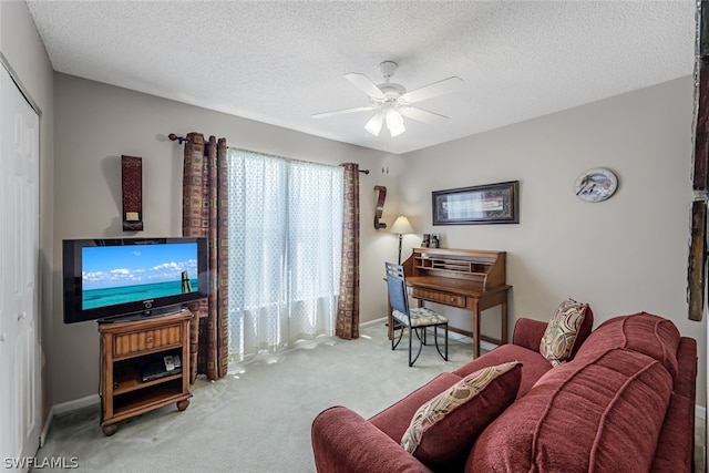 carpeted living room featuring ceiling fan and a textured ceiling