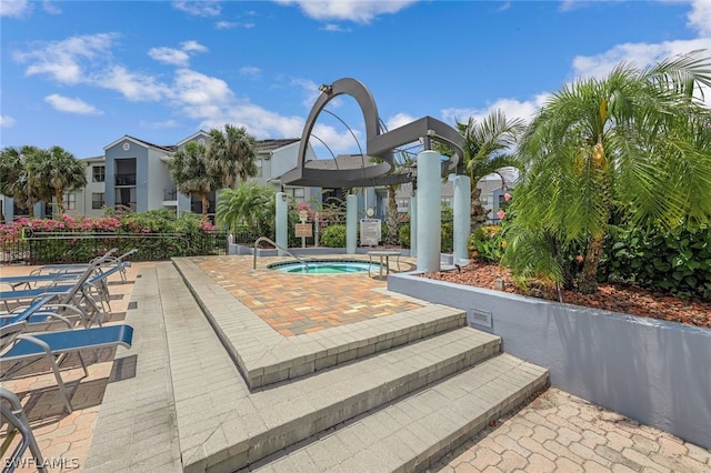 view of swimming pool featuring a patio and a hot tub