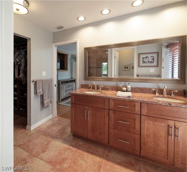 bathroom featuring plenty of natural light, tile floors, and dual bowl vanity