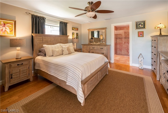 bedroom featuring hardwood / wood-style floors, ceiling fan, and ensuite bathroom