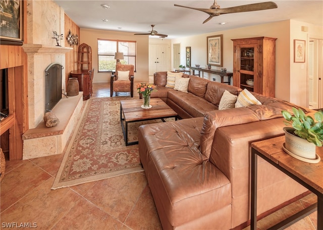 living room with ceiling fan, tile floors, and a premium fireplace