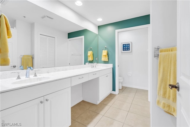 bathroom with tile floors, toilet, and dual bowl vanity