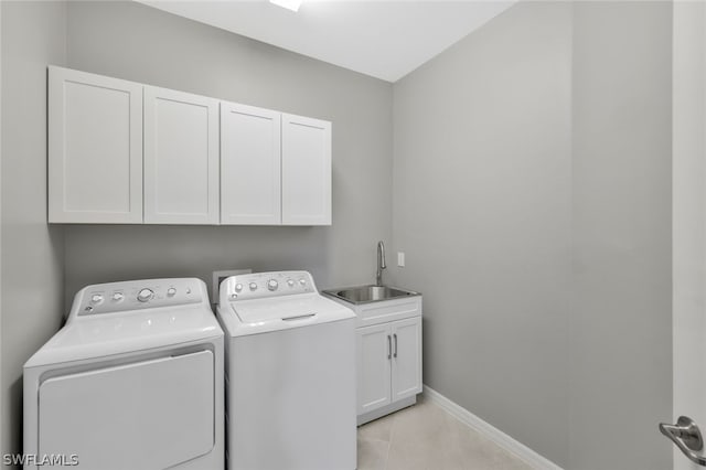 clothes washing area featuring cabinets, separate washer and dryer, sink, and light tile patterned floors