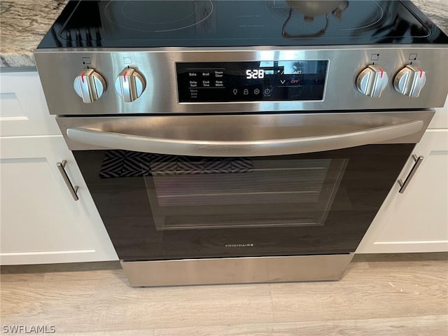 interior details with electric range and white cabinets