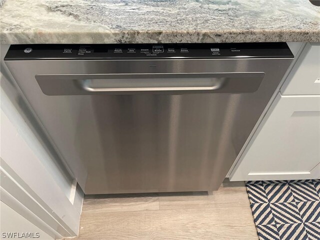 interior details with light stone counters, decorative backsplash, and dishwasher