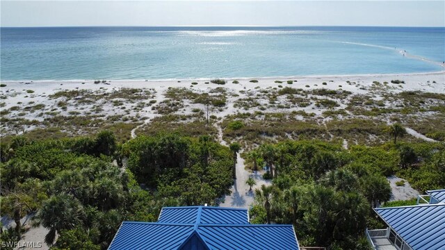 drone / aerial view featuring a water view and a beach view