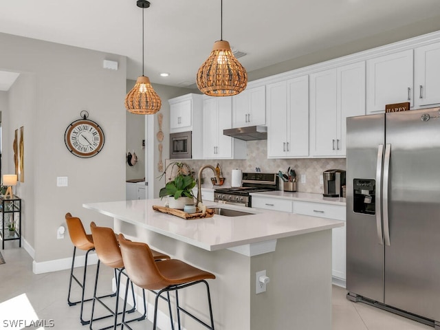 kitchen featuring pendant lighting, backsplash, light tile floors, and stainless steel appliances