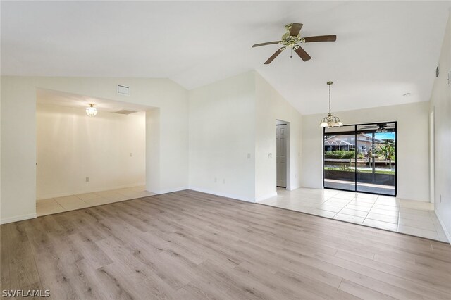 unfurnished living room featuring lofted ceiling, light wood-type flooring, and ceiling fan with notable chandelier