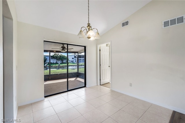 spare room with lofted ceiling, light tile patterned floors, and an inviting chandelier