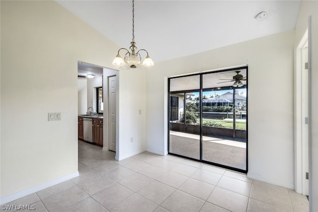 empty room with vaulted ceiling, ceiling fan with notable chandelier, sink, and light tile patterned floors