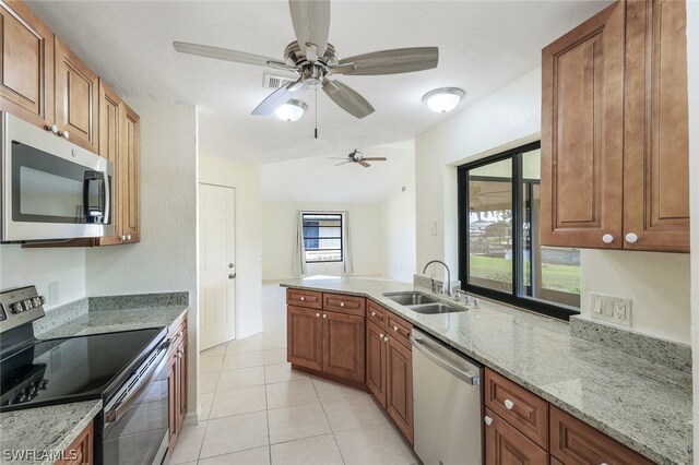 kitchen featuring light stone counters, light tile patterned flooring, sink, and stainless steel appliances