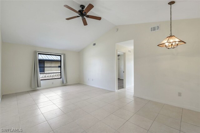 tiled empty room featuring ceiling fan with notable chandelier and vaulted ceiling