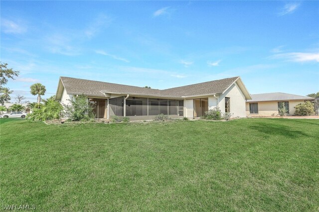 rear view of property featuring a sunroom and a yard