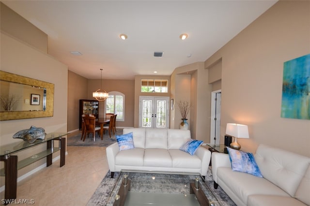 living room with light tile patterned floors, a notable chandelier, and french doors