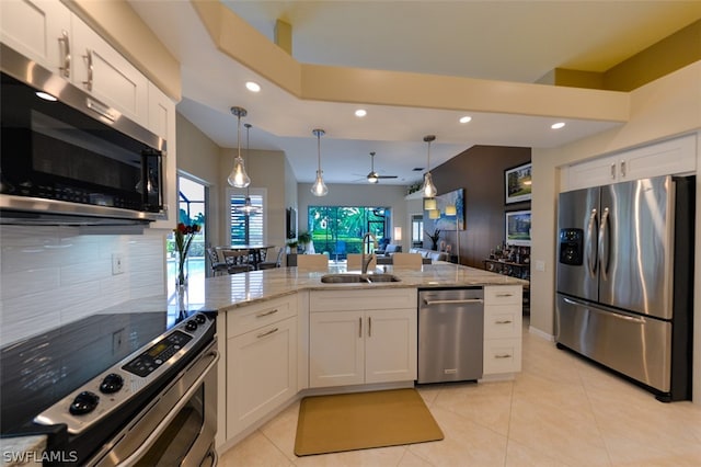 kitchen with appliances with stainless steel finishes, light stone countertops, sink, and white cabinets