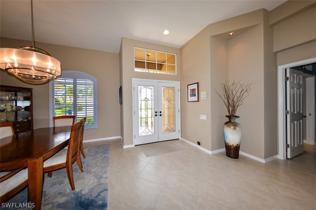 tiled foyer with a notable chandelier and french doors