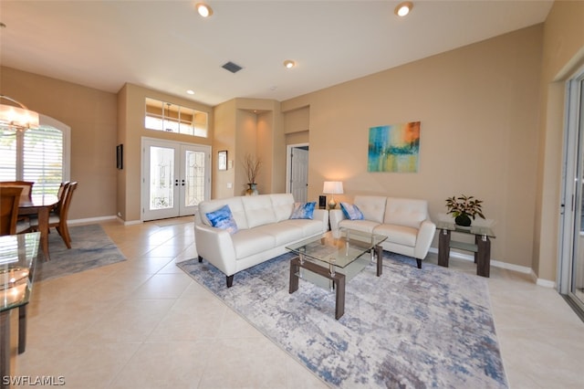 tiled living room featuring a notable chandelier and french doors