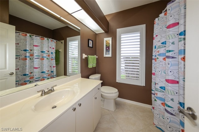 bathroom with vanity, toilet, tile patterned flooring, and a wealth of natural light