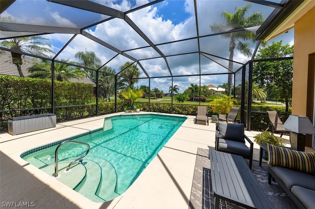 view of pool with a patio and glass enclosure