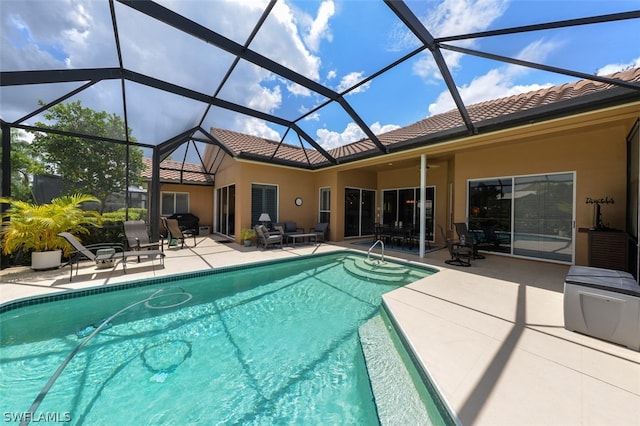 view of pool featuring a patio, ceiling fan, and glass enclosure