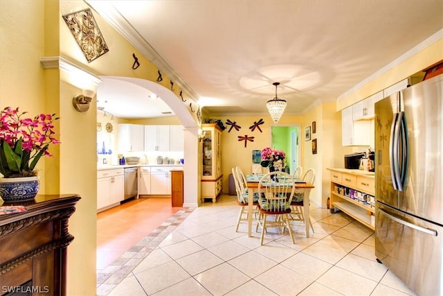 tiled dining space with crown molding and an inviting chandelier