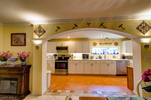 kitchen featuring light tile floors, white cabinets, sink, decorative columns, and stainless steel appliances