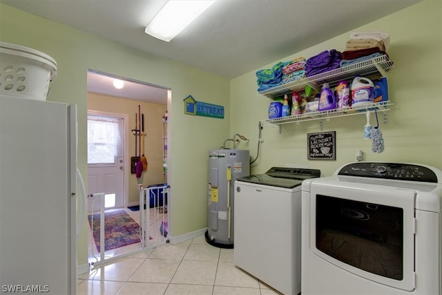 clothes washing area with water heater, washing machine and dryer, and light tile floors