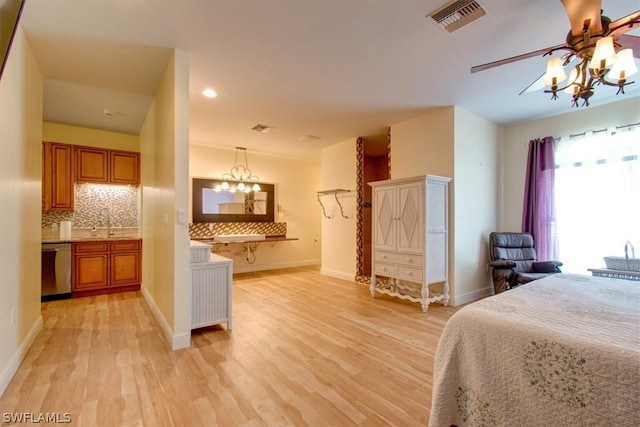 bedroom featuring ceiling fan with notable chandelier, light hardwood / wood-style floors, and sink