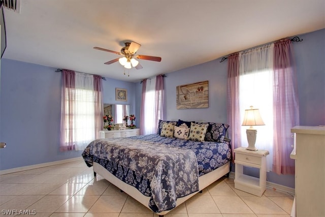 tiled bedroom with multiple windows and ceiling fan