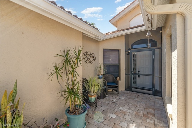 view of exterior entry with a patio