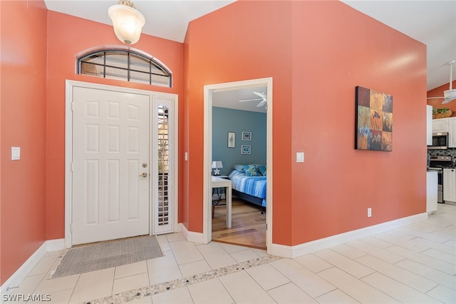 entryway with ceiling fan and light tile flooring