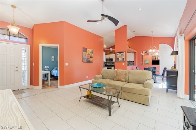 tiled living room with ceiling fan with notable chandelier and high vaulted ceiling