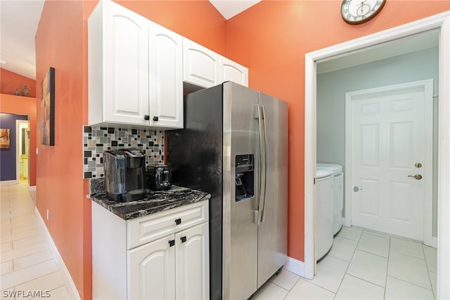 kitchen featuring tasteful backsplash, light tile flooring, white cabinetry, and washer and clothes dryer