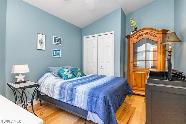 bedroom with a closet, lofted ceiling, ceiling fan, and light wood-type flooring