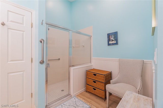 bathroom featuring wood-type flooring and an enclosed shower