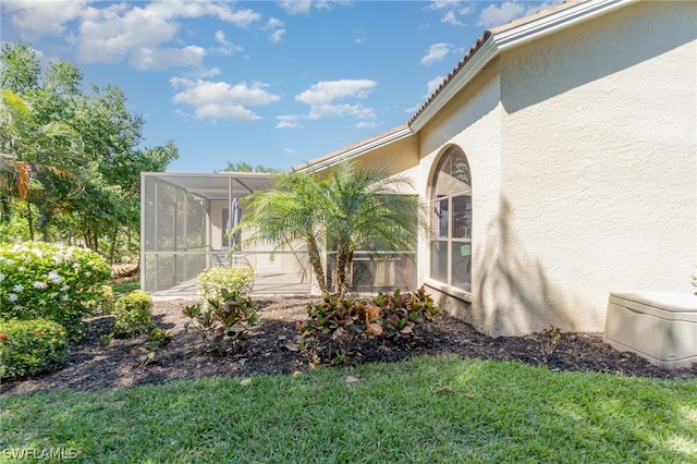 view of property exterior with a lawn and a sunroom