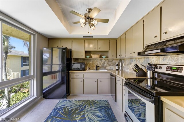 kitchen featuring a raised ceiling, cream cabinetry, appliances with stainless steel finishes, and light tile patterned floors