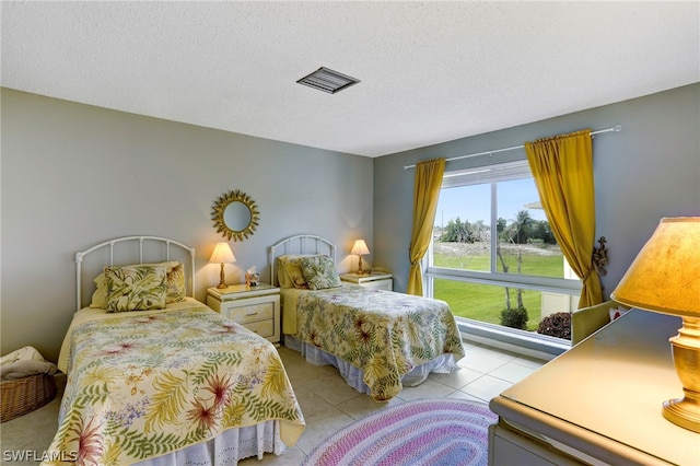 tiled bedroom with a textured ceiling