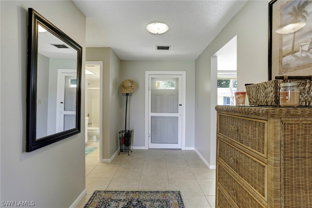 interior space with a textured ceiling and light tile patterned floors