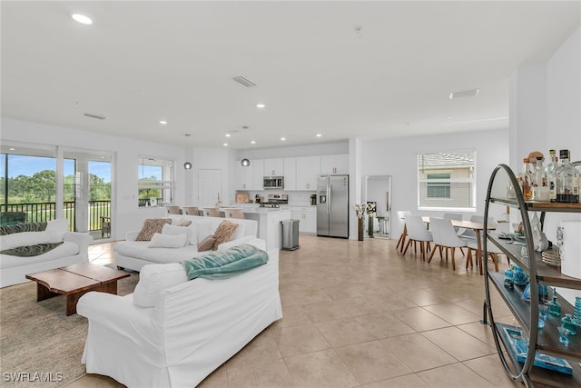 living room with recessed lighting, light tile patterned flooring, and visible vents