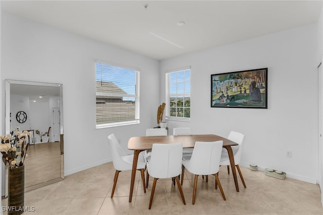 dining space featuring light tile patterned floors and baseboards