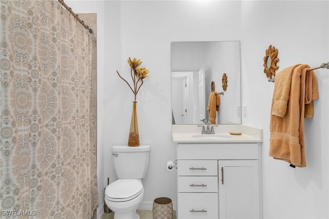 bathroom featuring vanity, baseboards, a shower with curtain, and toilet