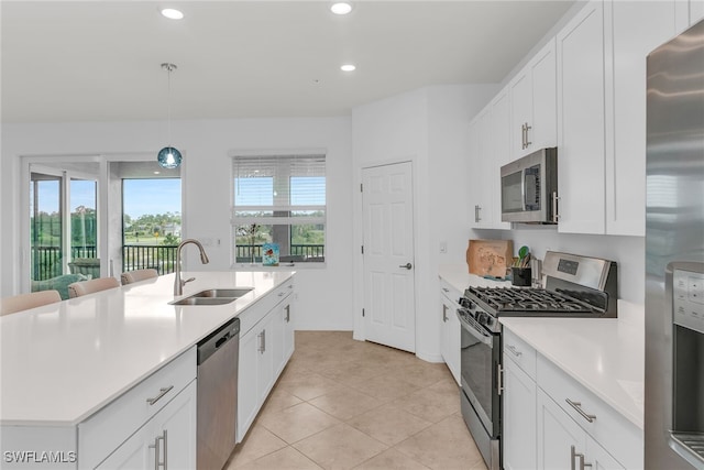 kitchen with light tile patterned flooring, light countertops, white cabinetry, a sink, and appliances with stainless steel finishes