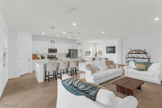 living room with visible vents, recessed lighting, and light tile patterned floors