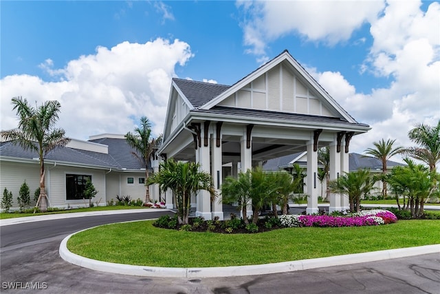 view of front of property with curved driveway and a front yard