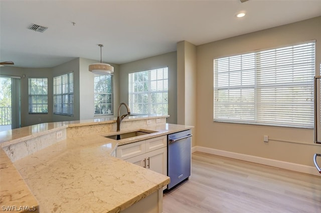 kitchen featuring decorative light fixtures, light hardwood / wood-style flooring, a wealth of natural light, sink, and stainless steel dishwasher