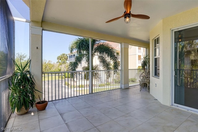 unfurnished sunroom featuring ceiling fan