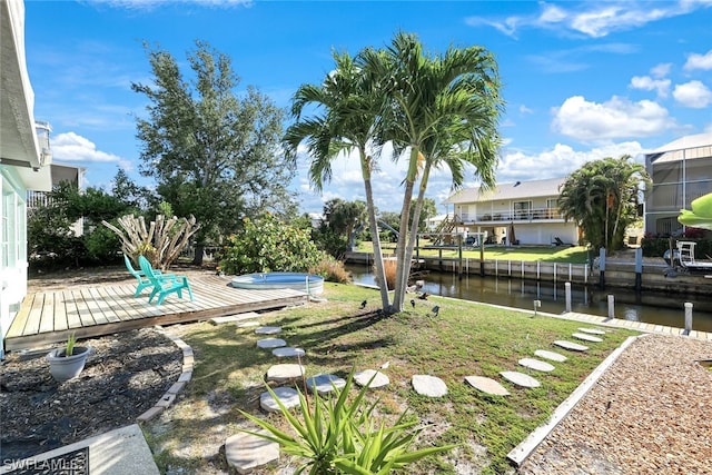 view of yard featuring a water view, glass enclosure, and a boat dock