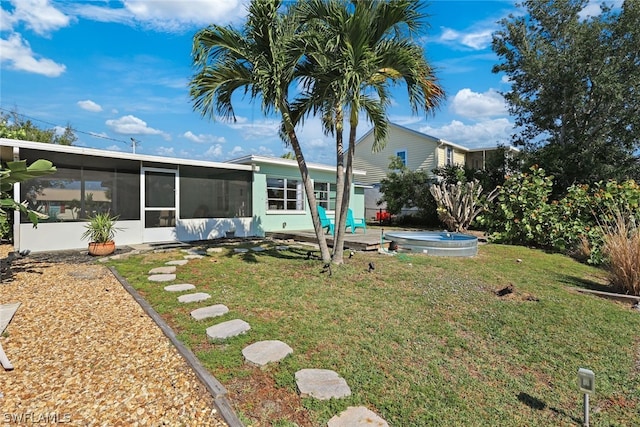 view of yard featuring a sunroom and a swimming pool