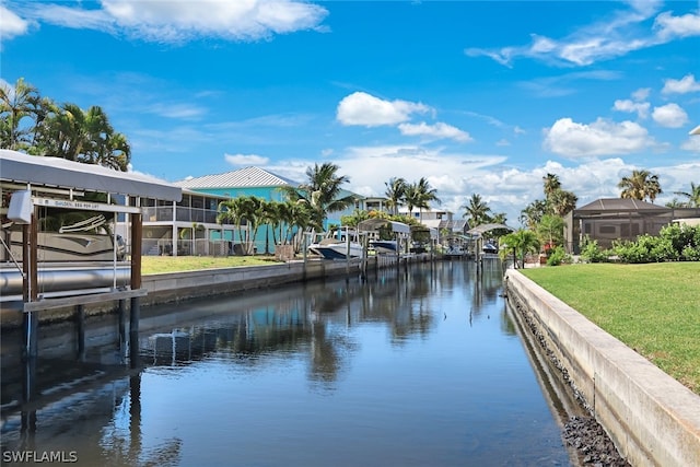 view of dock with a yard, a water view, and glass enclosure